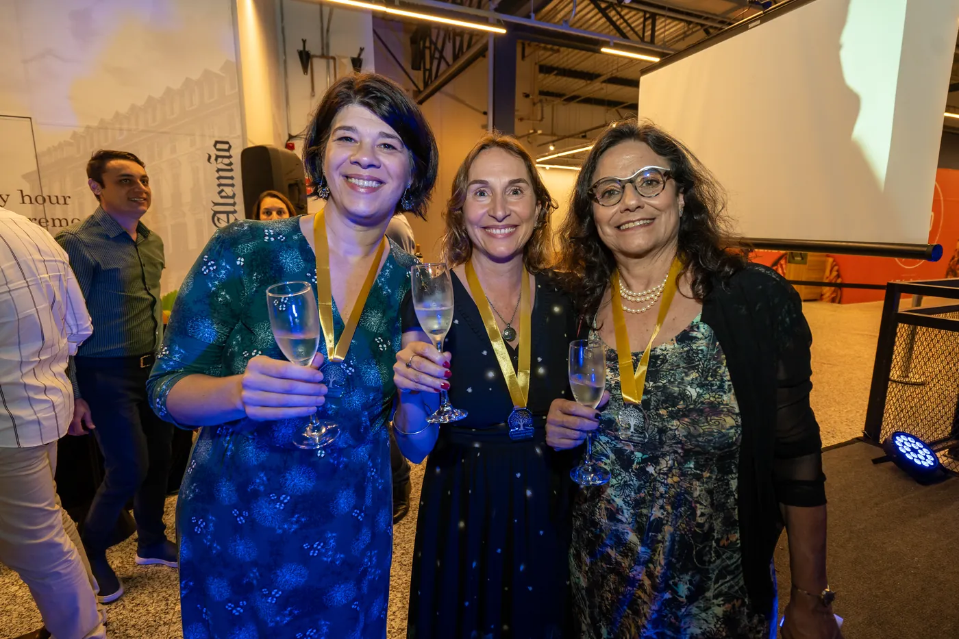 Produtoras premiadas brindando com medalhas