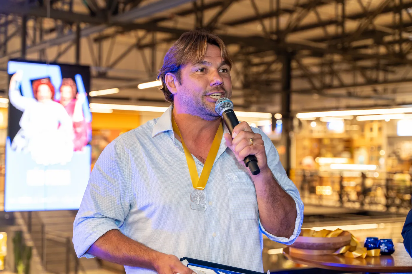 Produtor premiado discursando com medalha