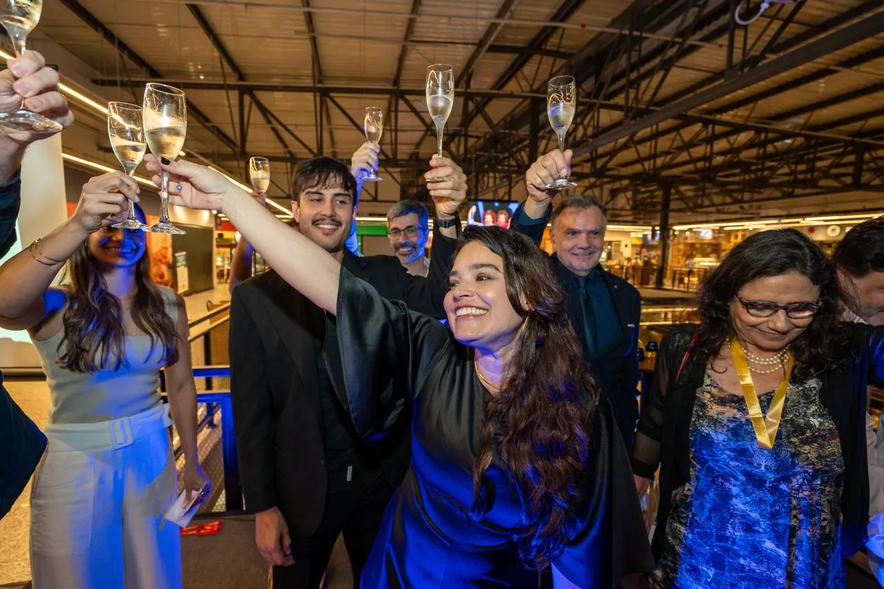 Participantes erguendo taças em brinde