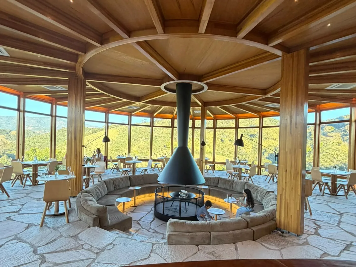 Salão da Pizzaria Sabiá, com lareira central e vista para a Serra da Mantiqueira